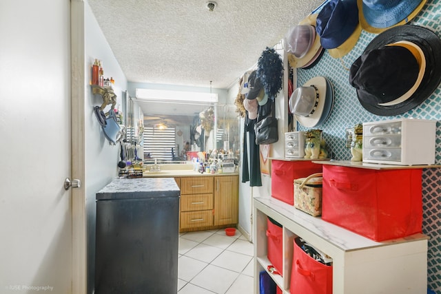 interior space with tile patterned flooring, vanity, and a textured ceiling