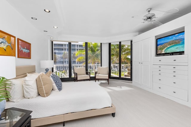 bedroom with access to exterior, multiple windows, expansive windows, and ceiling fan