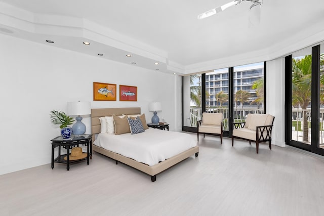 bedroom featuring access to outside and a wall of windows