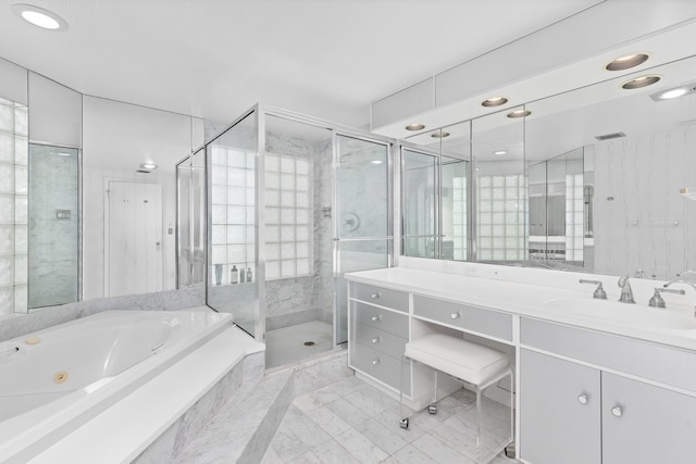 bathroom with vanity and shower with separate bathtub