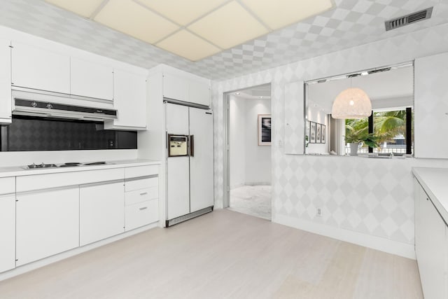 kitchen featuring white cabinets, decorative light fixtures, and white appliances