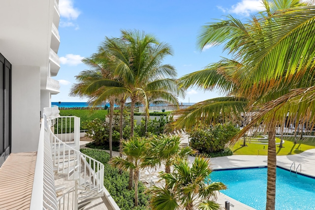 view of swimming pool featuring a water view and a patio area