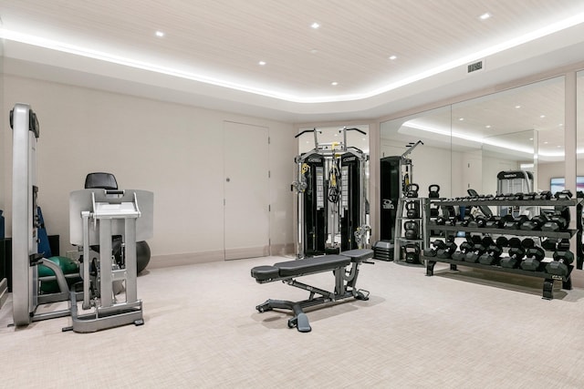 exercise room with carpet floors, a tray ceiling, and wood ceiling