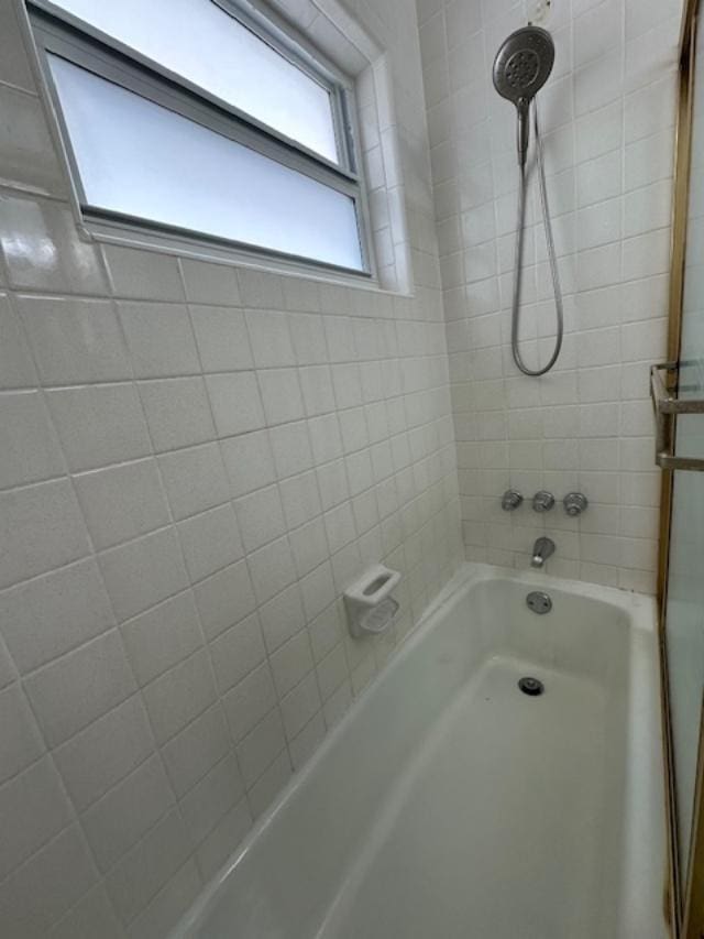 bathroom featuring tiled shower / bath