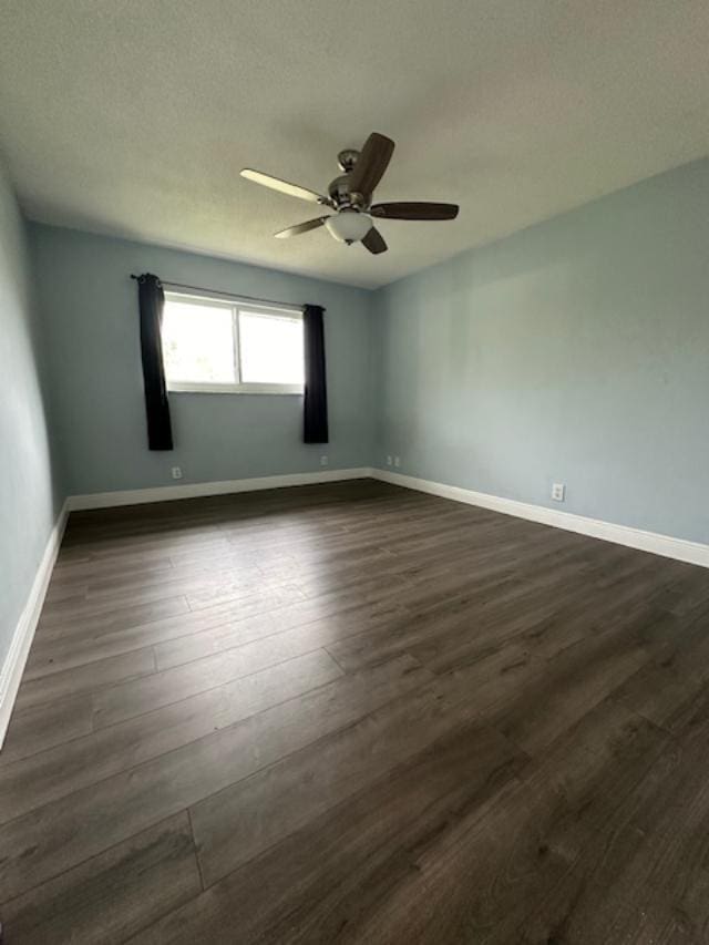 unfurnished room featuring ceiling fan and dark hardwood / wood-style flooring