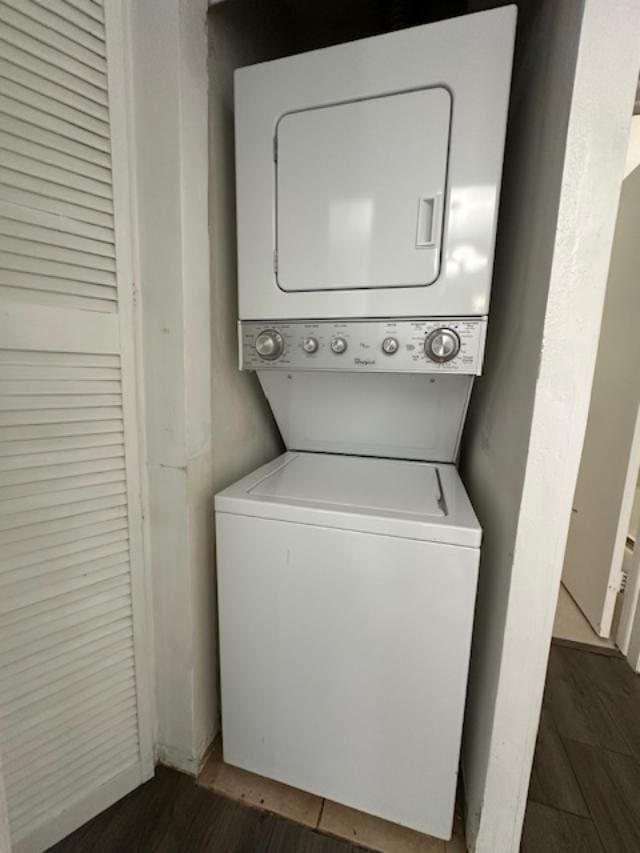 laundry area featuring dark hardwood / wood-style flooring and stacked washer / dryer