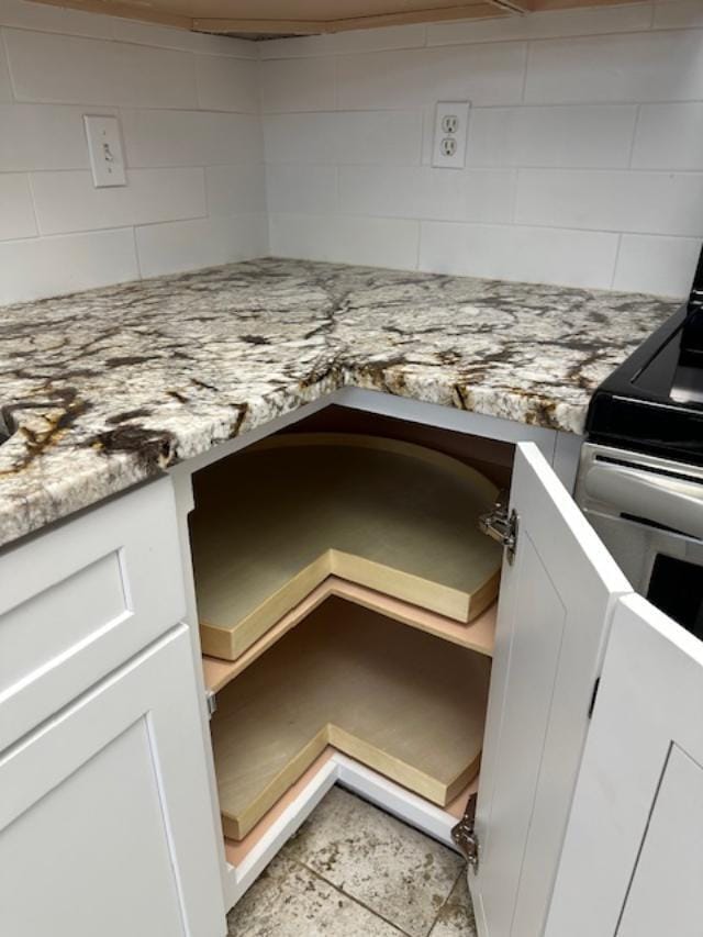 details with light stone counters, white cabinetry, and built in desk