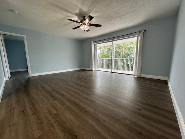 unfurnished room featuring ceiling fan, dark hardwood / wood-style flooring, and a textured ceiling