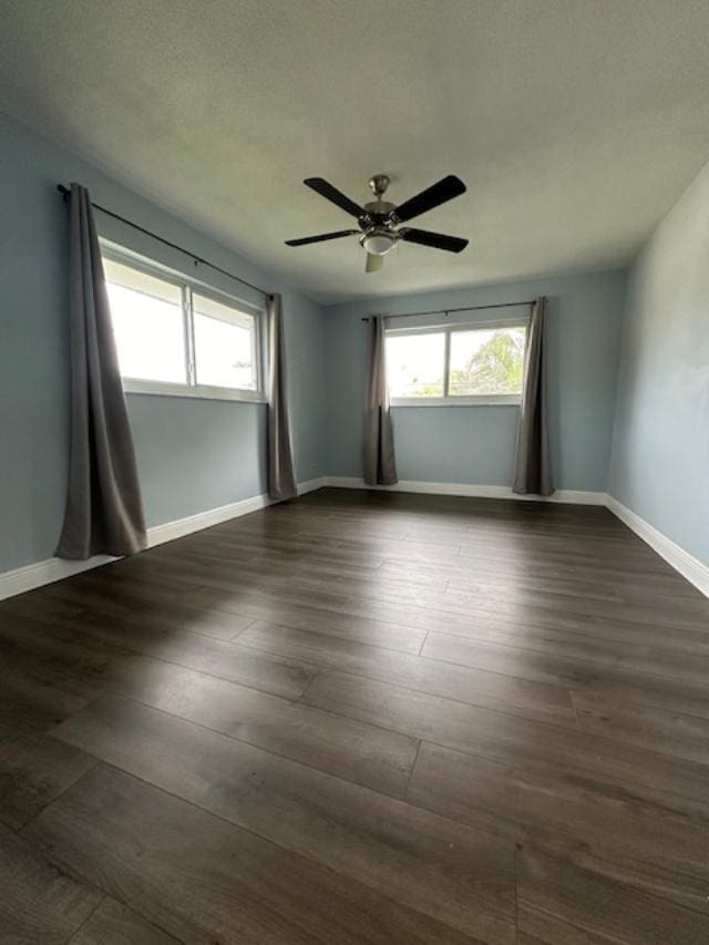 spare room featuring ceiling fan and dark wood-type flooring