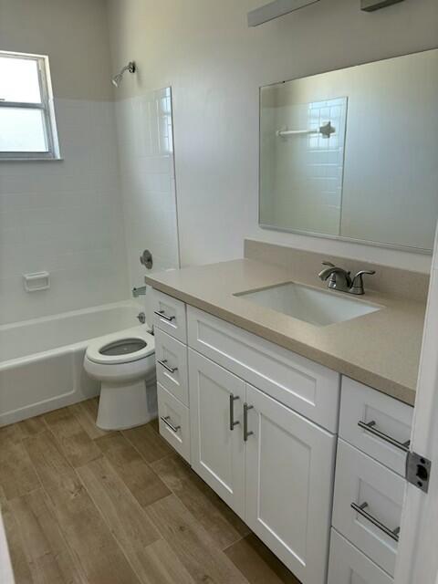 full bathroom with hardwood / wood-style flooring, vanity, toilet, and bathing tub / shower combination