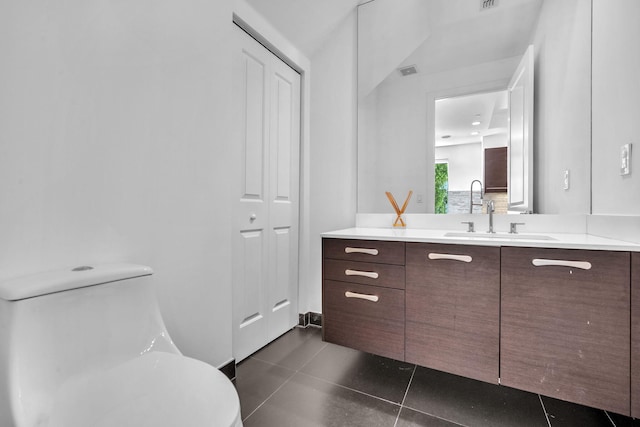 bathroom with tile patterned flooring, vanity, and toilet