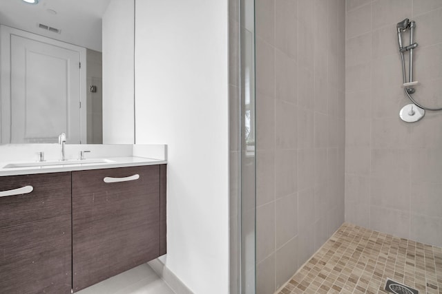 bathroom with vanity and tiled shower