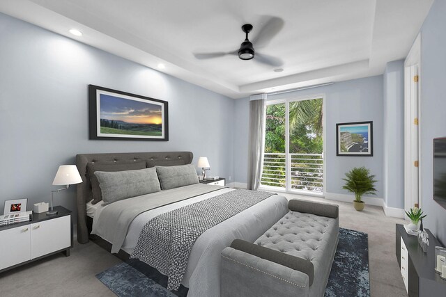 carpeted bedroom with a tray ceiling and ceiling fan