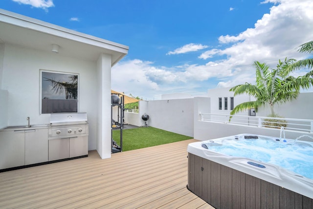 wooden deck featuring sink, a hot tub, and a grill