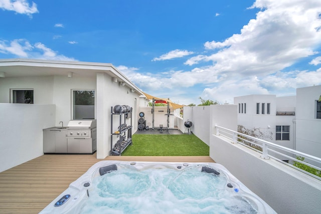 exterior space with a grill, a deck, and an outdoor hot tub