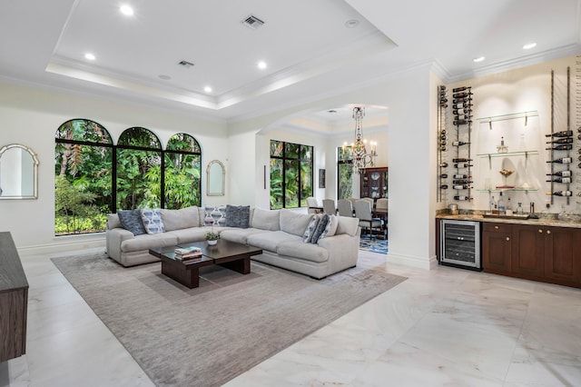 living room featuring a raised ceiling, crown molding, indoor bar, and beverage cooler