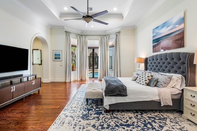 bedroom with dark wood-type flooring, ornamental molding, a raised ceiling, and ceiling fan