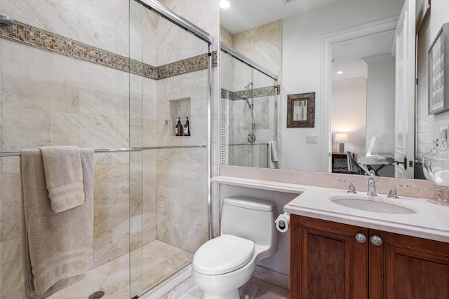 bathroom featuring an enclosed shower, vanity, crown molding, and toilet