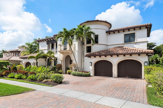 mediterranean / spanish house featuring a garage and a balcony