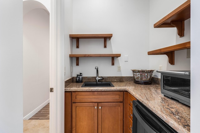 kitchen with sink, beverage cooler, and light stone counters