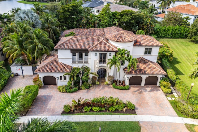 mediterranean / spanish-style house featuring a garage and a balcony