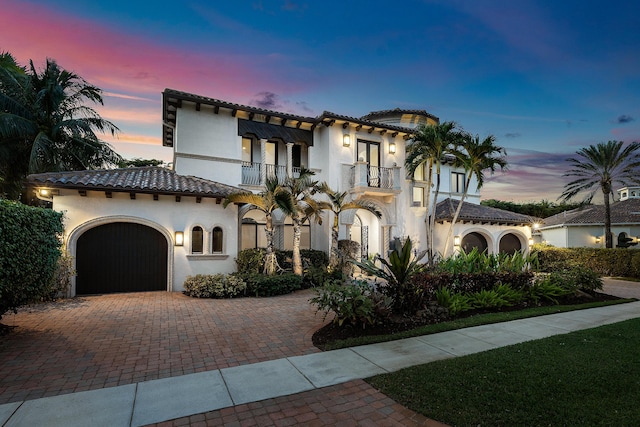 mediterranean / spanish-style house featuring a garage and a balcony