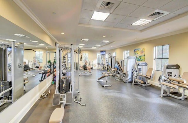 exercise room featuring a paneled ceiling, ornamental molding, and a tray ceiling