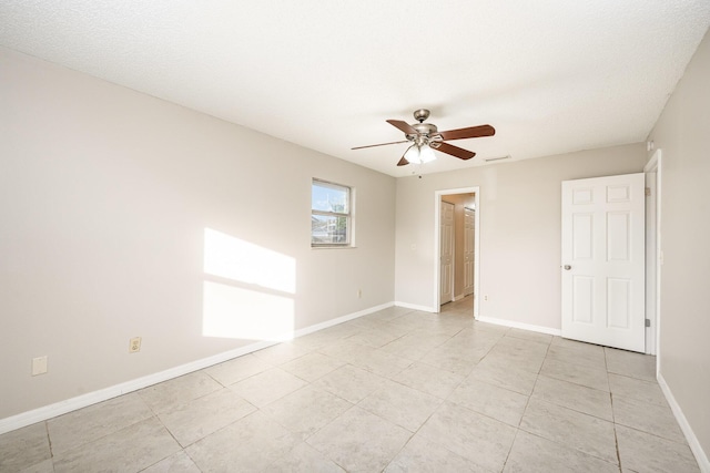 spare room featuring ceiling fan and light tile patterned flooring