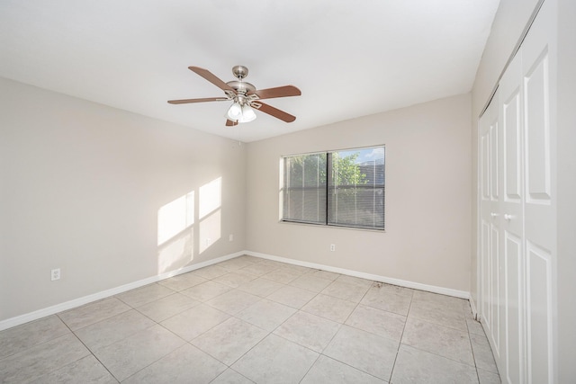 unfurnished bedroom featuring ceiling fan, a closet, and light tile patterned flooring