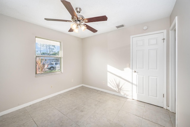 tiled empty room with ceiling fan