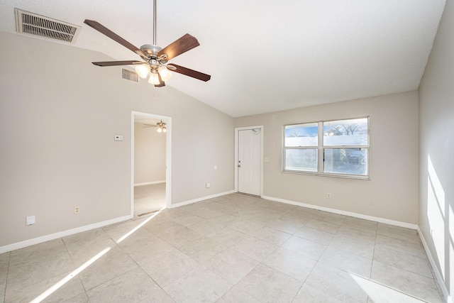 empty room with ceiling fan, lofted ceiling, and light tile patterned floors