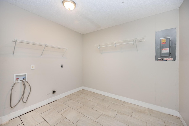 washroom with hookup for an electric dryer, hookup for a washing machine, a textured ceiling, and electric panel