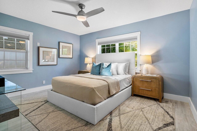 bedroom with light hardwood / wood-style floors and ceiling fan