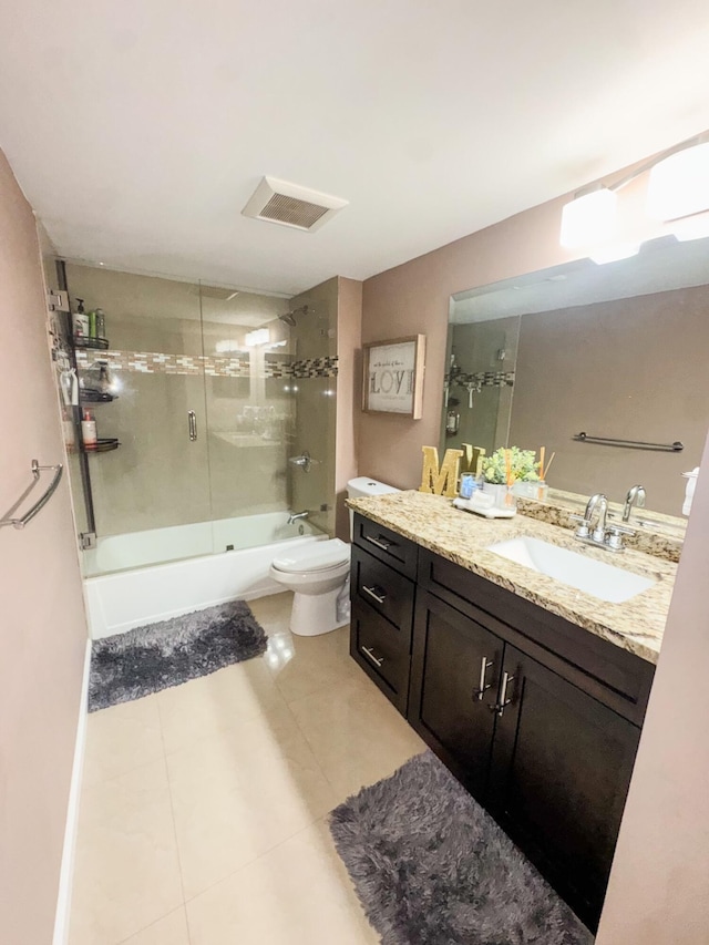 full bathroom with tile patterned flooring, vanity, toilet, and bath / shower combo with glass door