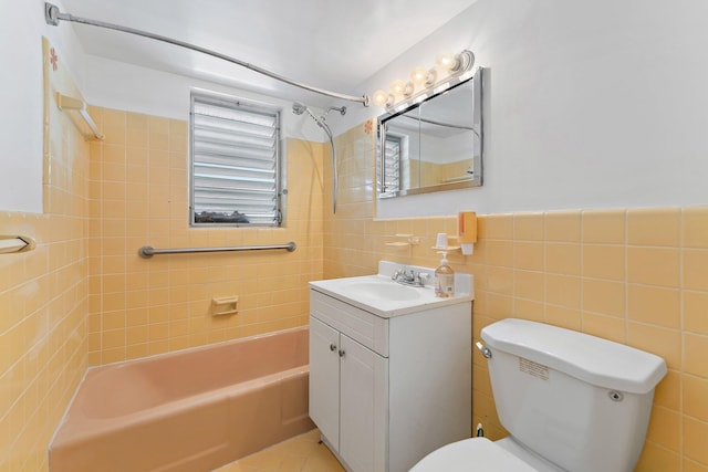 full bathroom featuring vanity, toilet, tiled shower / bath, and tile walls