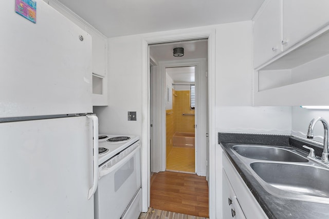 kitchen with white cabinetry, light hardwood / wood-style flooring, white appliances, and sink