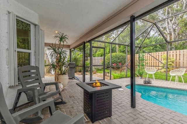 view of swimming pool featuring a lanai, an outdoor fire pit, a grill, and a patio