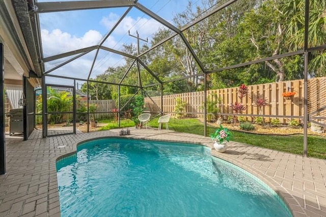 view of swimming pool with a patio and glass enclosure