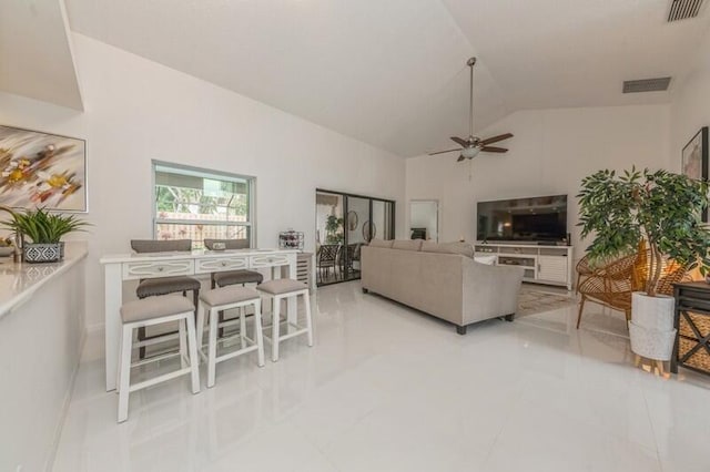 tiled living room with ceiling fan and vaulted ceiling