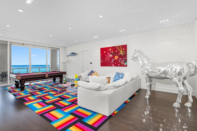 living room featuring dark hardwood / wood-style flooring, a water view, a wall of windows, and billiards