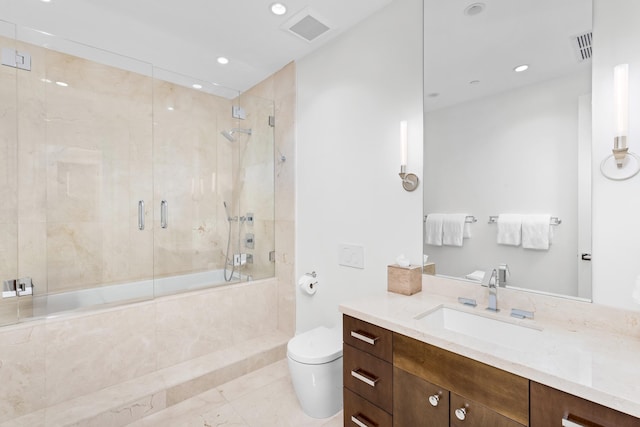 full bathroom with combined bath / shower with glass door, tile patterned floors, vanity, and toilet