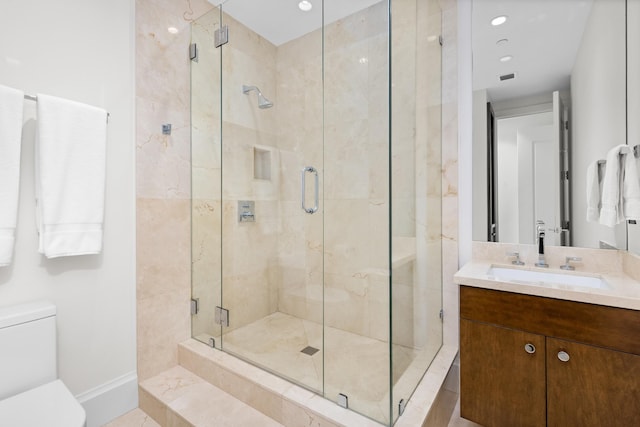 bathroom featuring vanity, toilet, and a shower with door