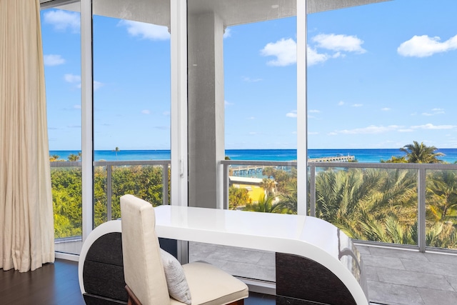 dining room with a water view, a beach view, and wood-type flooring