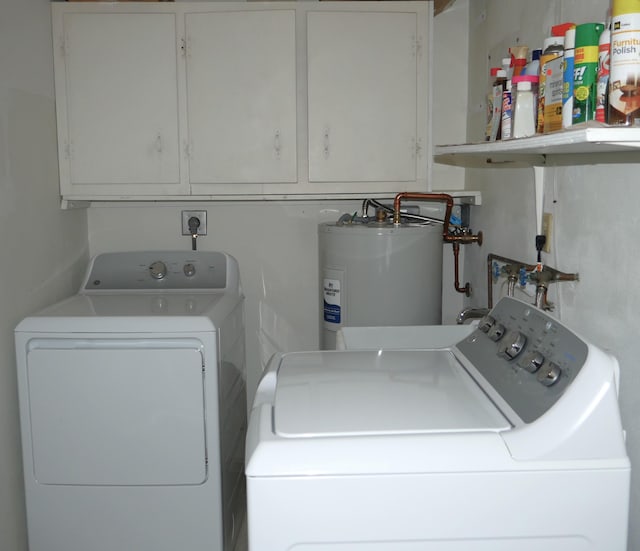 laundry area with washing machine and dryer, water heater, and cabinets