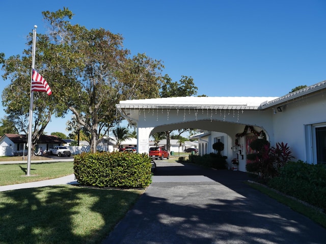 view of parking featuring a yard and a carport