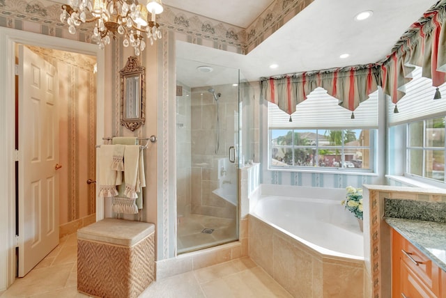 bathroom with vanity, independent shower and bath, and a notable chandelier