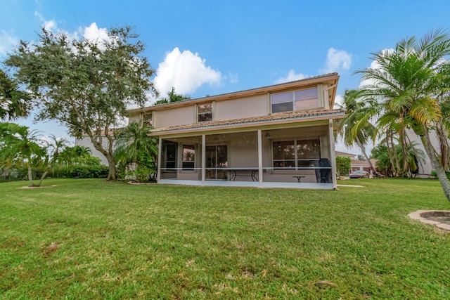 back of property featuring a sunroom and a lawn