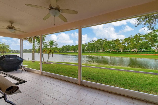 unfurnished sunroom featuring a water view, plenty of natural light, and ceiling fan