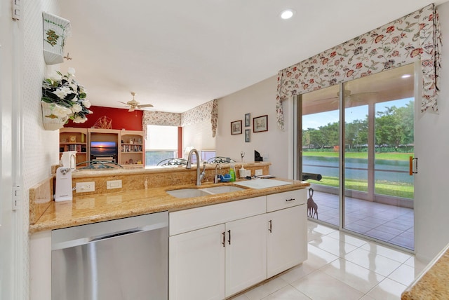 kitchen with white cabinets, ceiling fan, sink, light tile patterned floors, and dishwasher