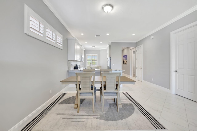 dining area with crown molding and sink